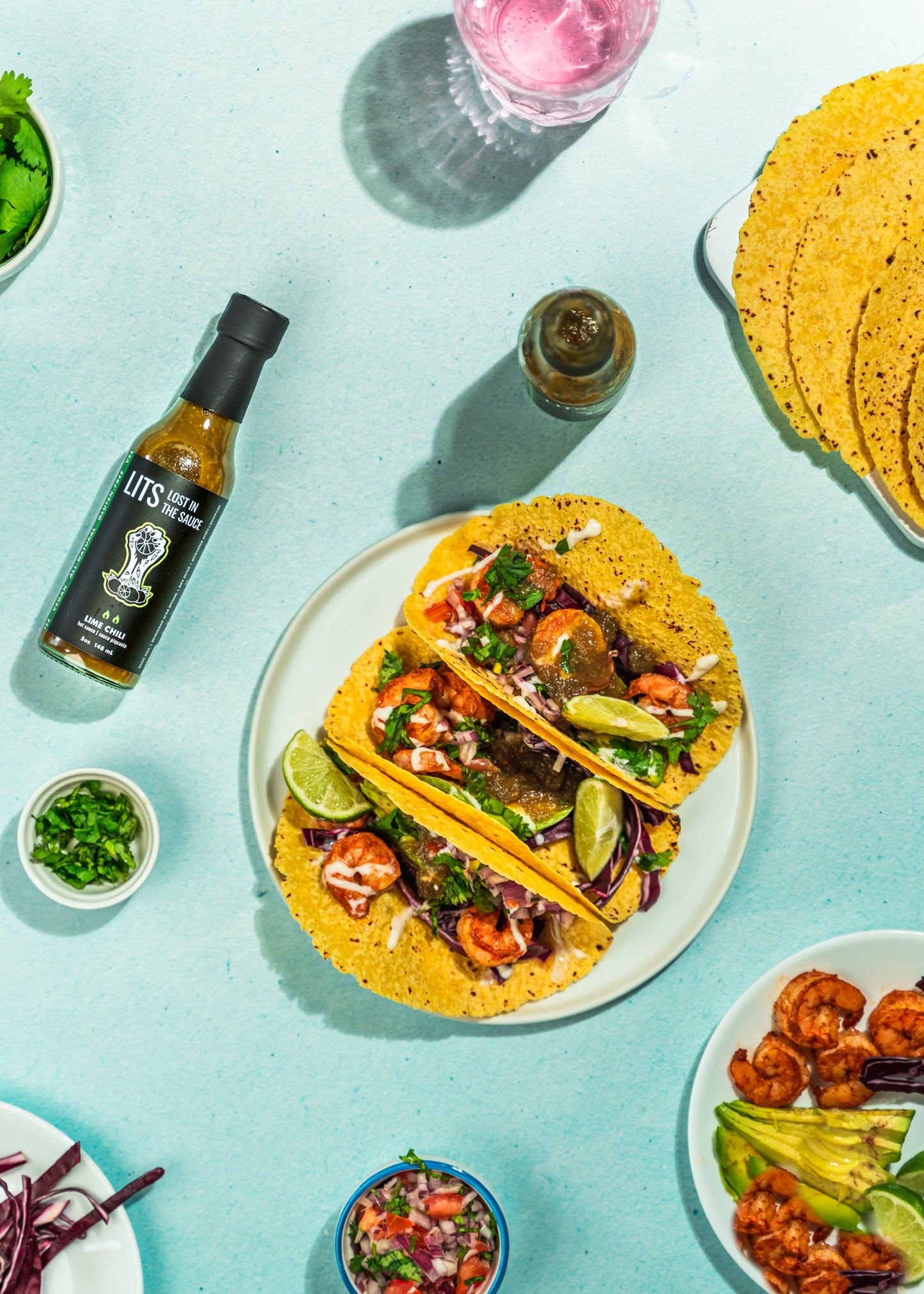 Shrimp tacos topped with LITS Lime Chili hot sauce, lime slaw, and avocado