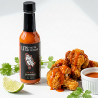 OG Boodoo Trinidadian pepper sauce bottle with saucy fried chicken wings, lime and cilantro (hover), photo 3