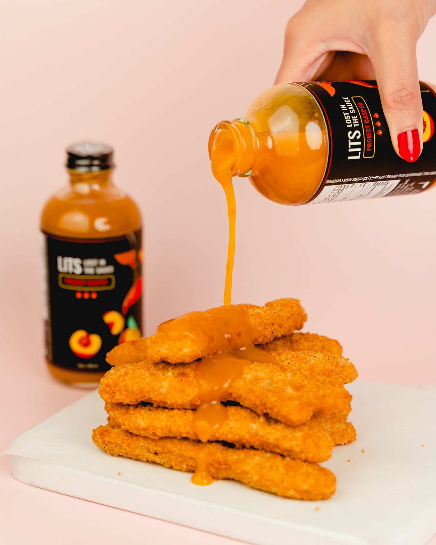 
                  
                    Peach Bhut Jolokia Ghost Pepper Hot Sauce Pouring Over Fried Chicken Strips
                  
                